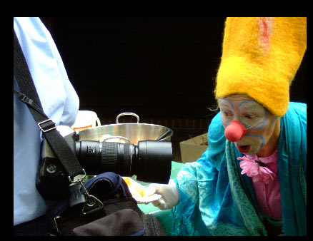 Clown Moro betrachtet ein riesiges Kameraobjektiv